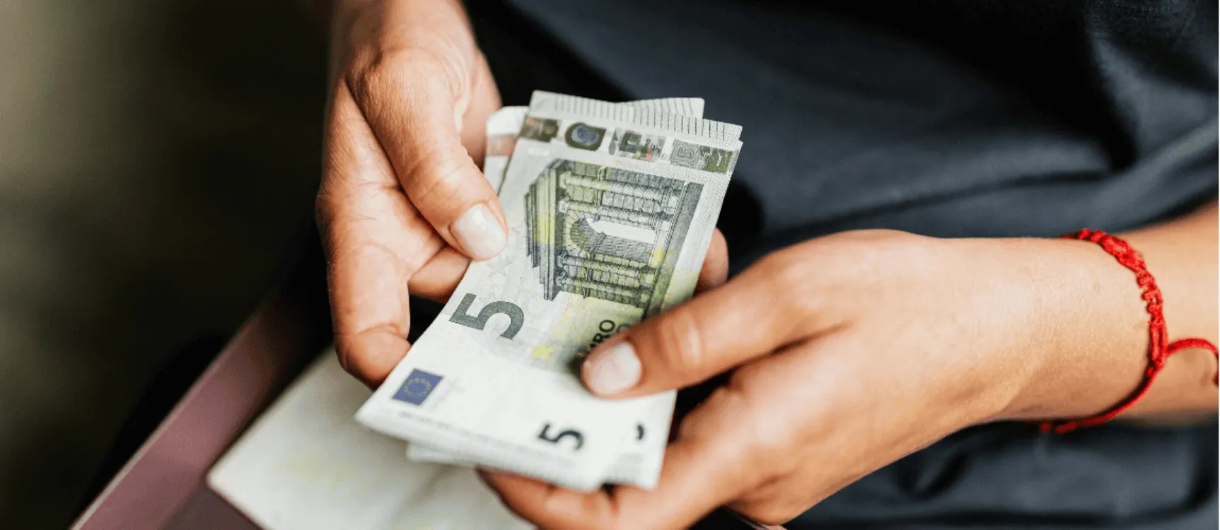 Entlastungsbetrag für Pflegebedürftige: Mann hält Bündel 5 Euro Scheine in der Hand