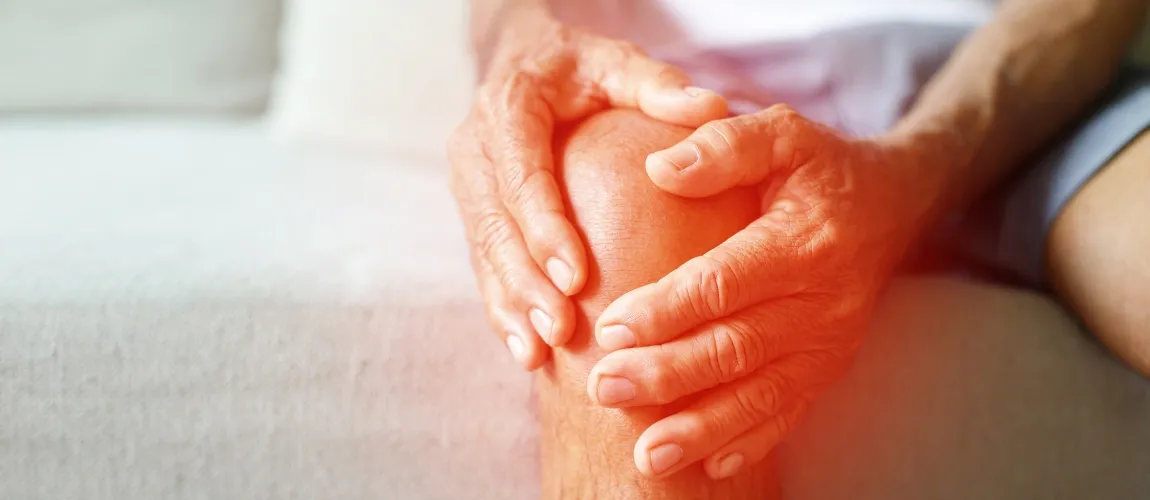 Ein Mann greift sich an das schmerzende Knie. 
