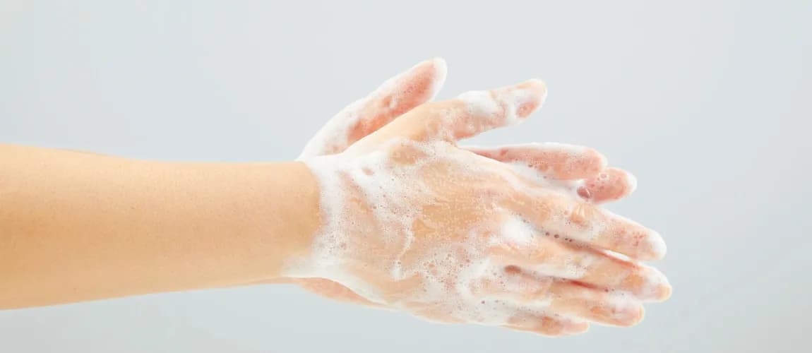 Mit Schaum bedeckte Hände in der Nahaufnahme.