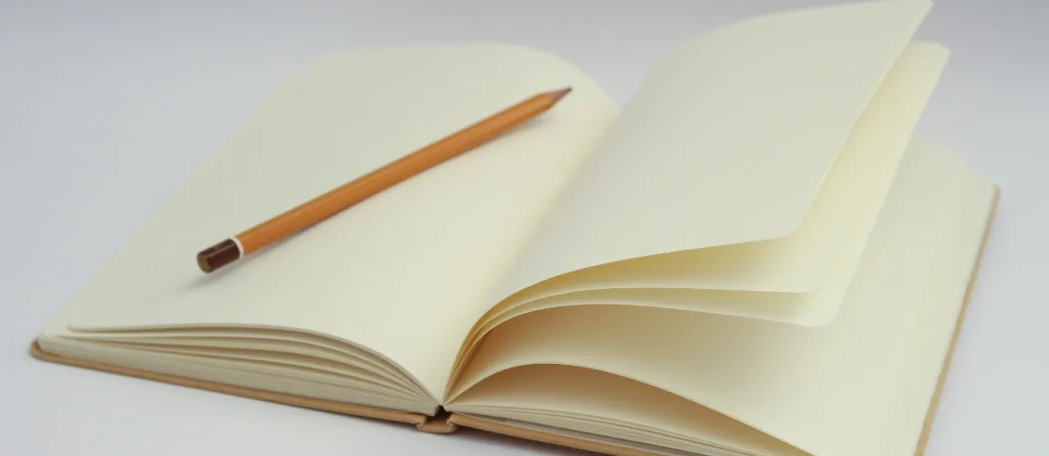 Ein Stift liegt auf einem aufgeschlagenen Buch.