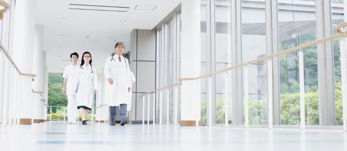 Medizinisches Personal geht einen Gang in einer Einrichtung entlang.