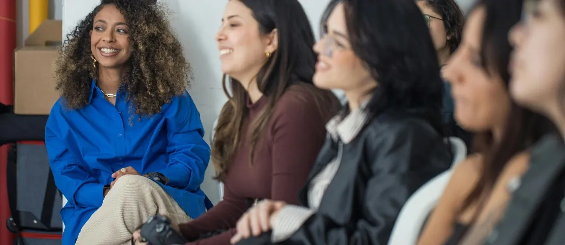 Eine Gruppe Frauen sitzt zusammen und lächelt.