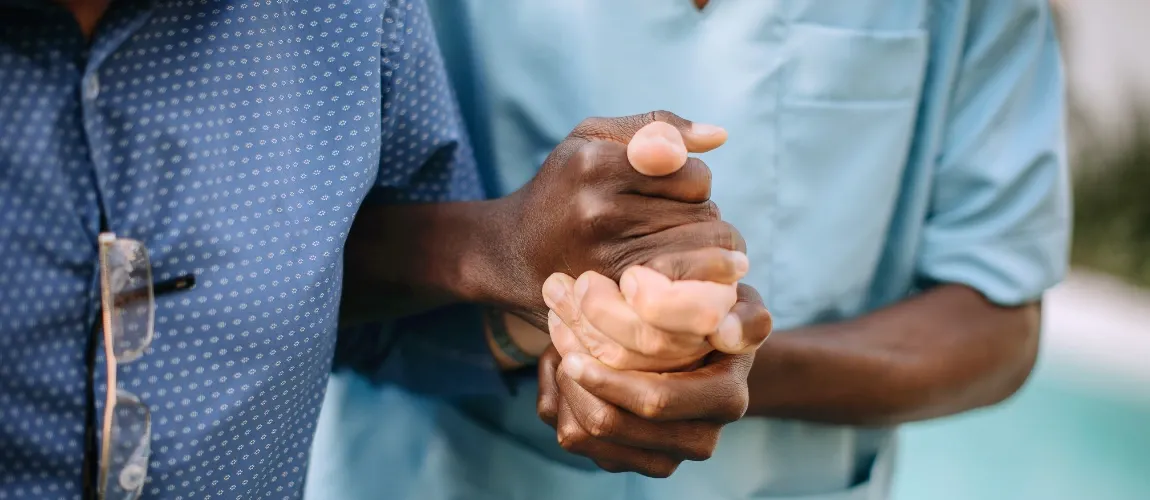 Nahaufnahme einer Pflegekraft, die die Hand eines Patienten hält.
