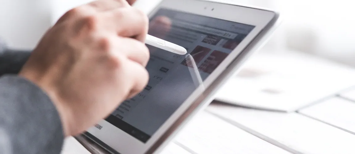 Eine Person bedient ein Tablet mit einem Stift