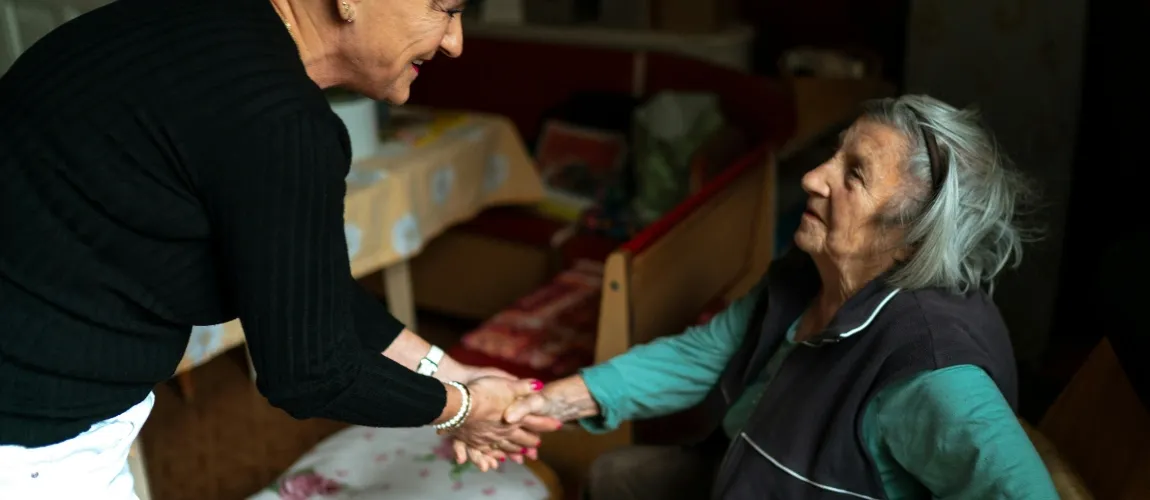 Eine Frau hält die Hand einer Senior:in