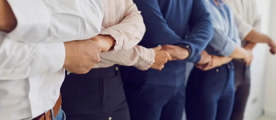 Menschen stehen nebeneinander und reichen sich die Hand.