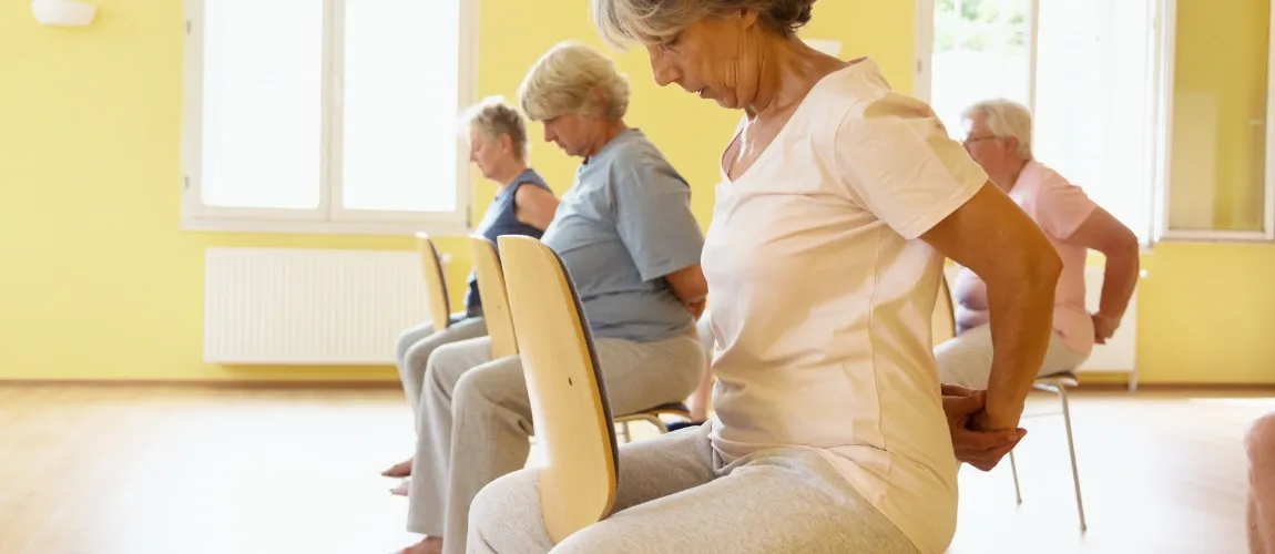 Es sind Senior:innen bei der Sitzgymnastik zu sehen.