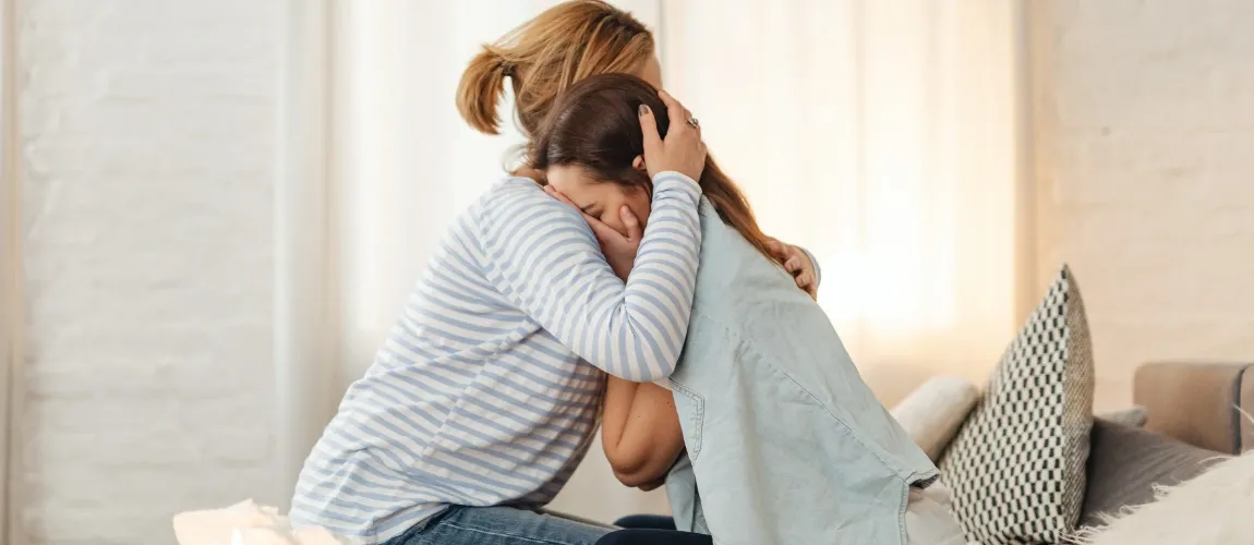 Eine Frau hält ein Mädchen im Arm.