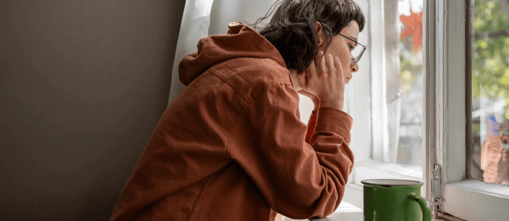 Introviertiert als Pflegekraft: Frau sieht aus dem Fenster