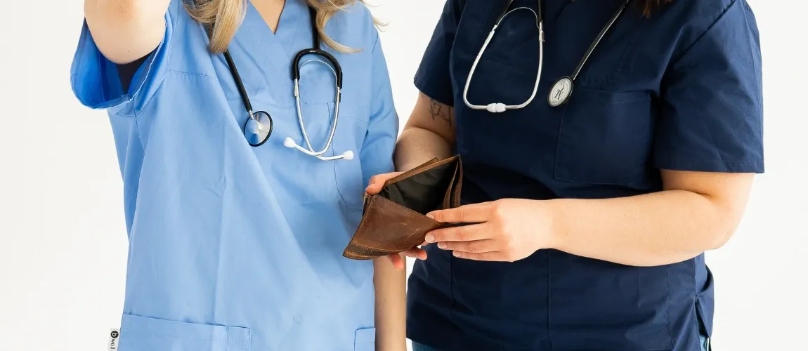 Pflegekräfte halten leeren Geldbeutel in der Hand