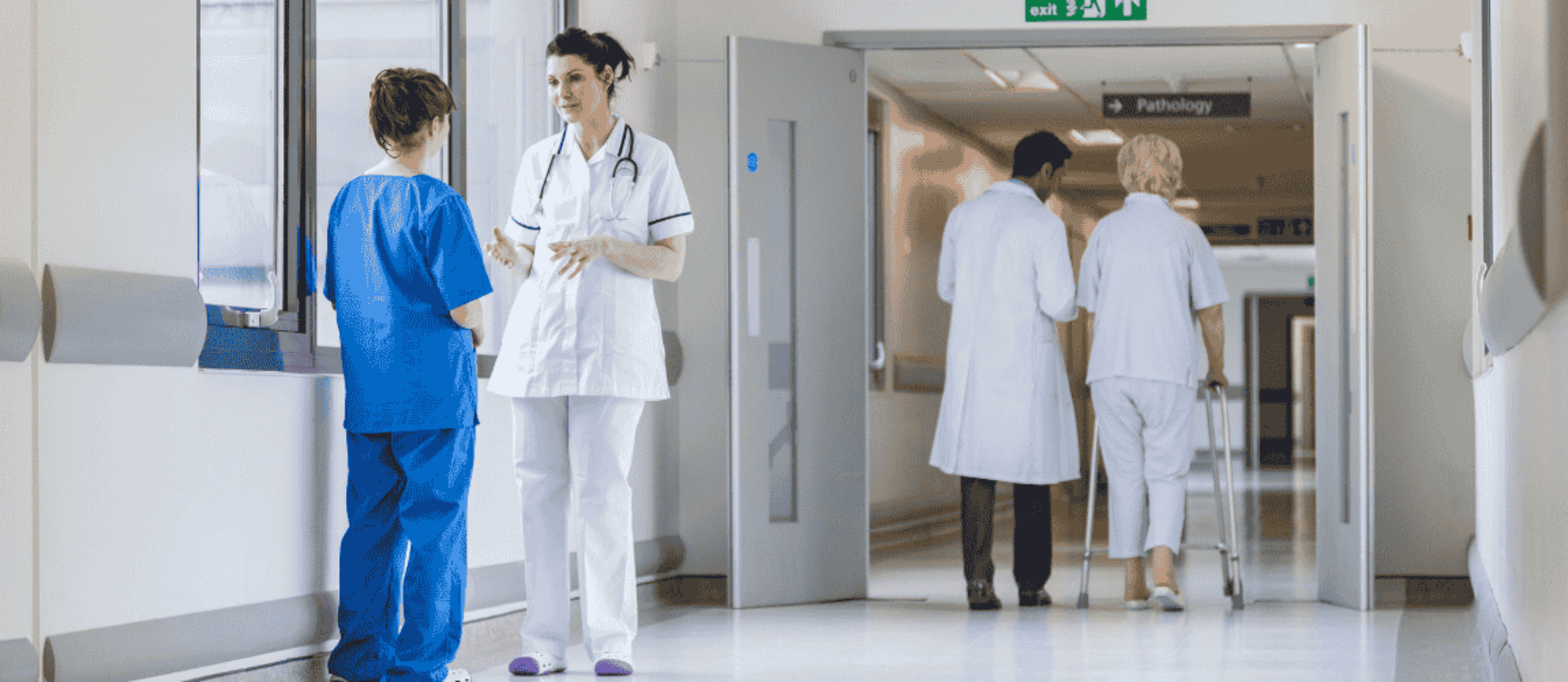 Ärztin unterhält sich mit Pflegerin im Krankenhausgang
