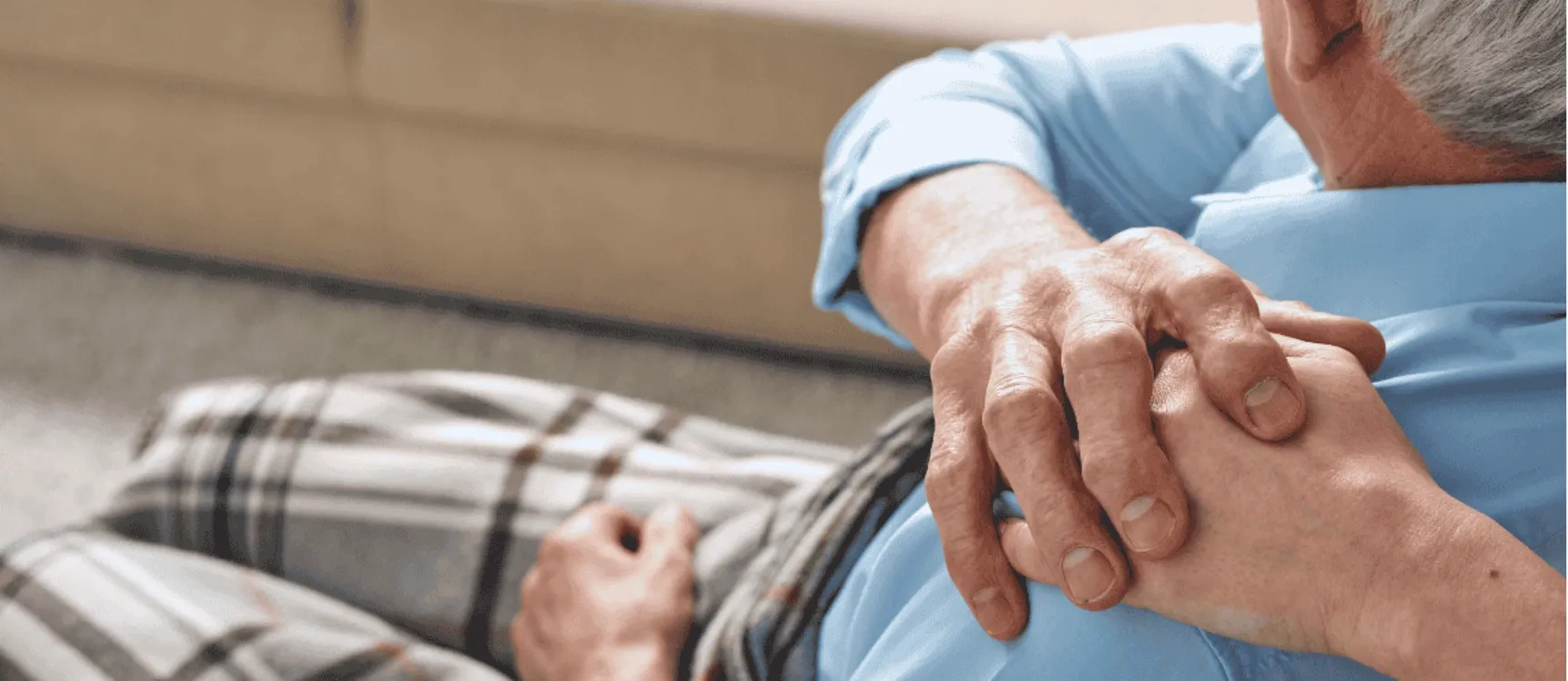 Pflegende Angehörige legt Hand auf die Schulter ihres Vaters