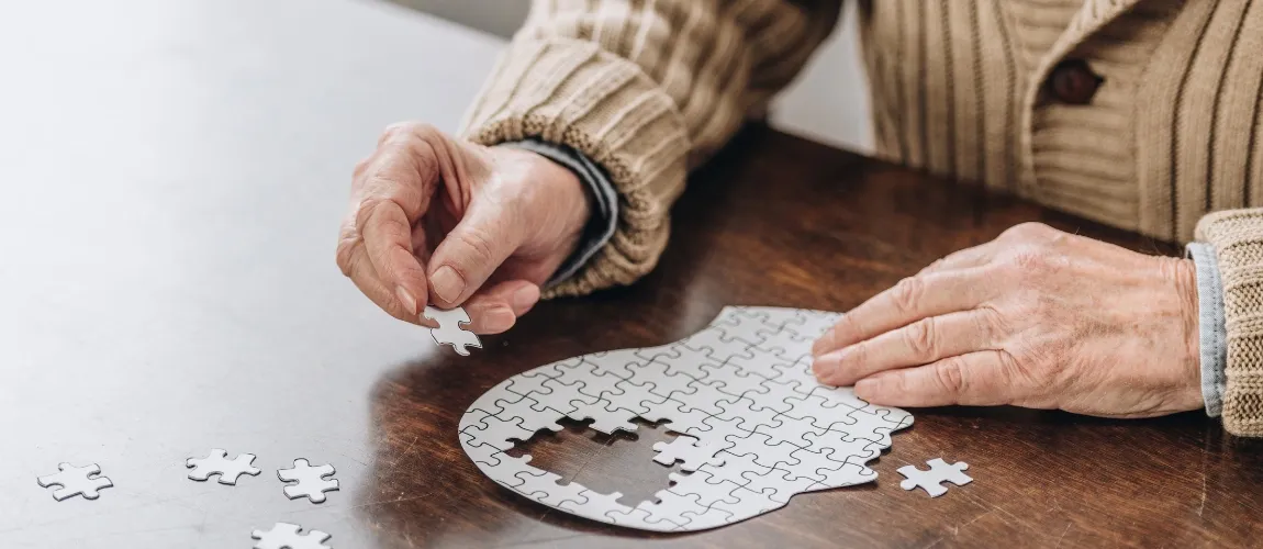 Ein Mann mit Demenz macht ein Puzzle. 