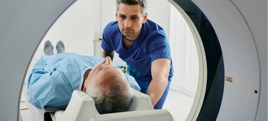Ein Pfleger bereitet einen Patienten auf eine Magnetresonanztomografie vor. 
