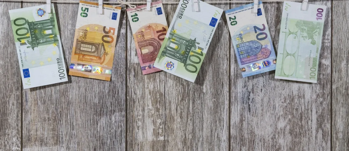 Verschiedene Euroscheine liegen auf einem hölzernen Untergrund.