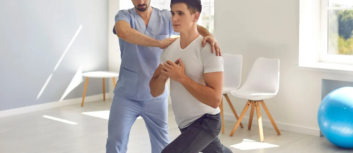 Ein Therapeut hilft einem Patienten Übungen richtig durchzuführen.