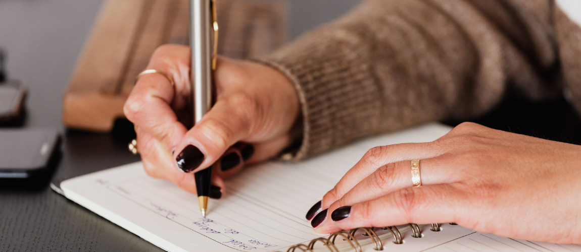 Eine Frau macht Notizen in einem Buch.