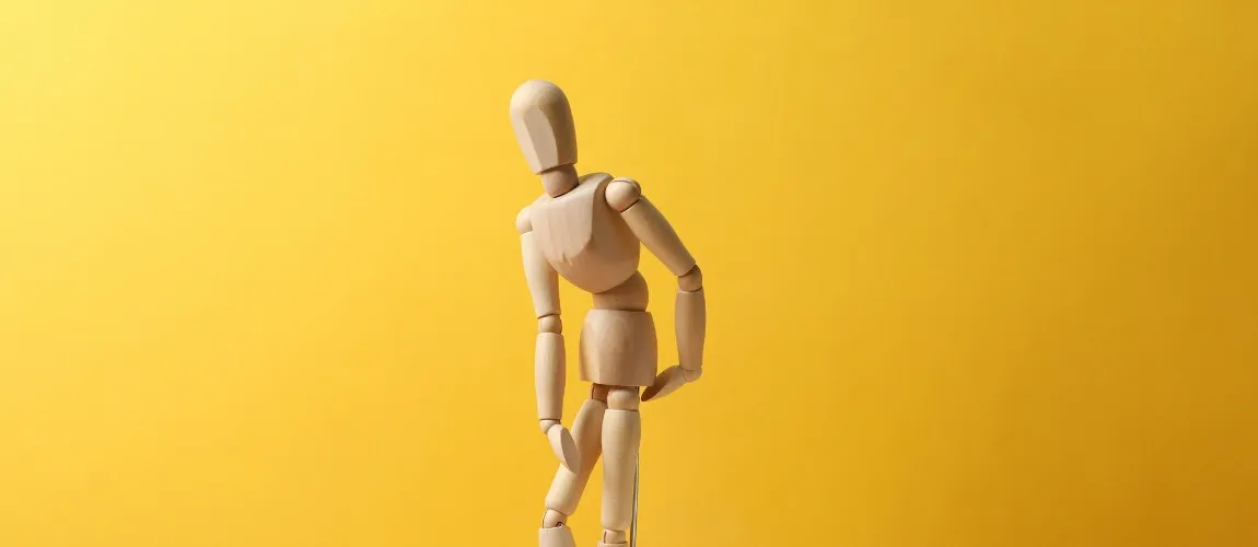 Eine Modellfigur "fasst" sich an die Rückseite.